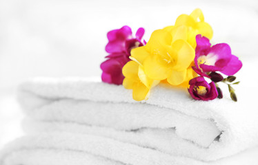 Obraz na płótnie Canvas Colorful beautiful freesias on fresh towels in hotel, close up