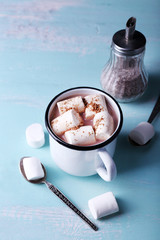 Mug of cocoa with marshmallows on wooden table background