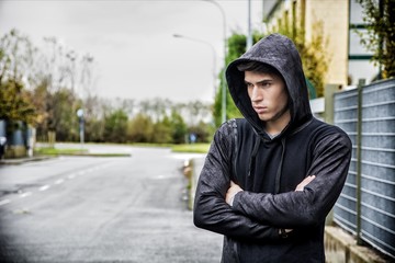Handsome young man in black hoodie sweater standing outdoor
