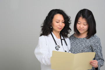 Female Doctor with female patient and medical chart