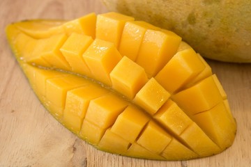Fresh yellow mango cut on Block.