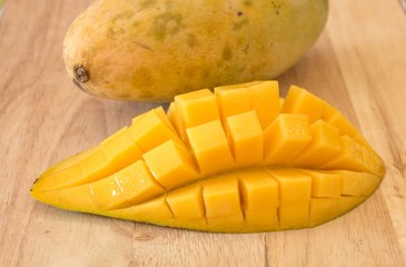 Fresh yellow mango cut on Block.
