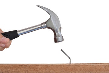 Close up hammer hitting a nail into wood on white background.
