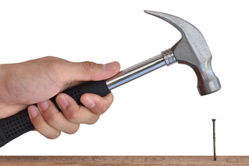 Close up of builder's hands hammering a nail into wood.