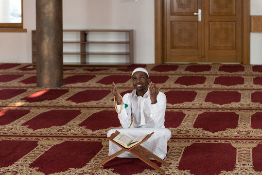 Young African Muslim Guy Reading The Koran