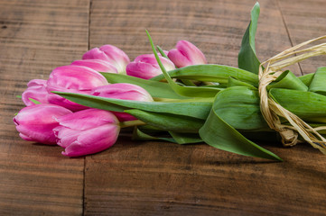 Bouquet of pink tulips on a wooden table