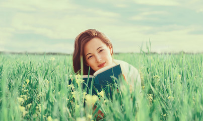 Woman with a book on summer meadow