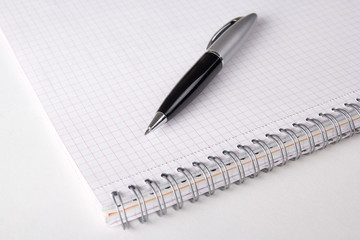 note book with checked pages and pen on the table