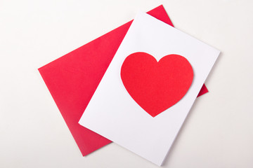 love concept - handmade card with red paper heart over white
