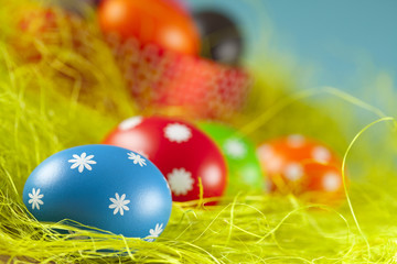 Colored Easter eggs on the grass and blue sky background