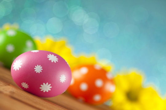 Colored Easter eggs and flowers on blue background