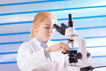 technician in the laboratory using a microscope