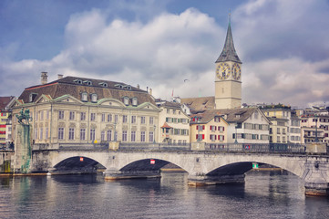 Obraz premium Munster bridge over Limmat river in Zurich. St. Peter Church