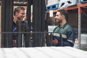Smiling warehouse workers talking together