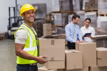 Worker carrying box in warehouse