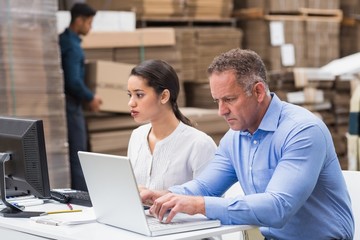 Fototapeta na wymiar Warehouse managers working with laptop at desk