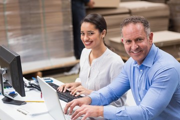 Warehouse managers working with laptop at desk
