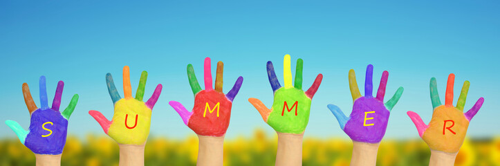Obraz premium Kid's painted hands against blue sky