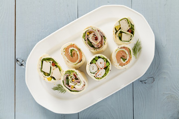 Mix of wraps with ham, chicken, salmon and crab served
