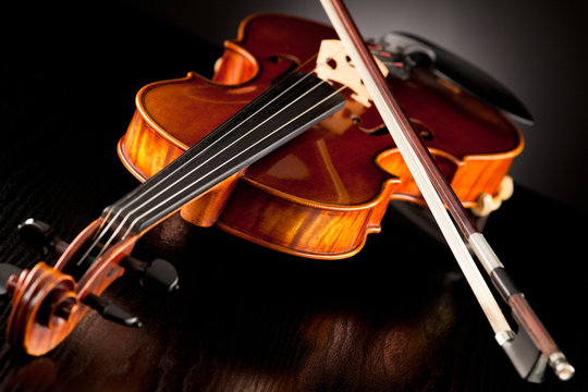 Violine mit Bogen vor dunklem Hintergrund