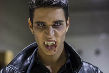 Naklejka premium Young Vampire Man Face with Blood on his Mouth