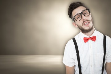 Composite image of geeky young hipster looking at camera