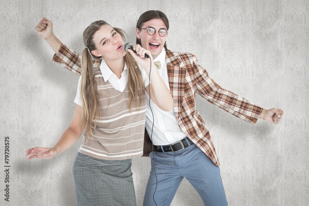 Poster Composite image of happy geeky hipsters singing with microphone