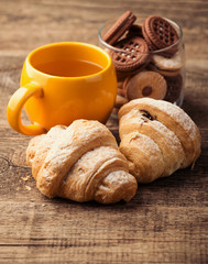 tea and croissant on wooden table