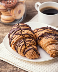 Cappuccino and croissant on wooden table