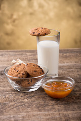 glass of milk and cookie on wooden background