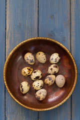 quail eggs on dish on blue background