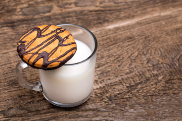 glass of milk and cookie on wooden background