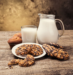 Breakfast with coffee, milk and coockies on wooden table