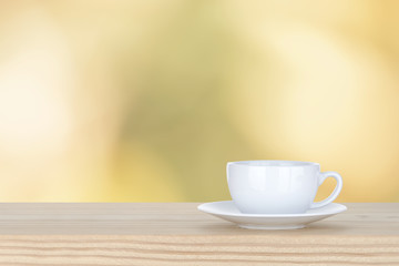 white cup of coffee on pine Wooden Table and bokeh,defocused lig