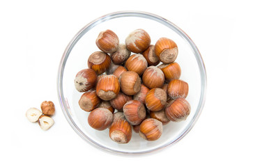 Hazelnuts on bowl on white background viewed from above