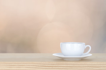 white cup of coffee on pine Wooden Table and bokeh,defocused lig