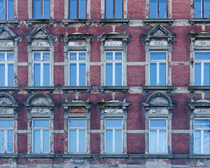 facade of an old building with windows reflecting the blue sky