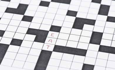 Closeup of crossword puzzle and the word eat