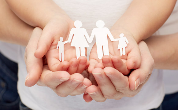 close up of woman and girl hands with paper family