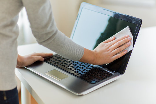 close up of woman hands cleaning laptop screen