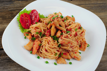 Pasta. Spaghetti with sauce and chicken on a plate.