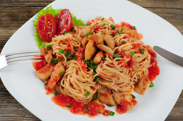 Pasta. Spaghetti with sauce and chicken on a plate.