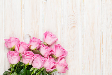 Pink roses bouquet over wooden table