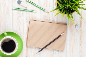 Office desk table with supplies, coffee cup and flower