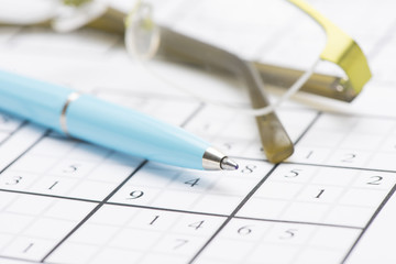 Sudoku puzzle, pen and glasses