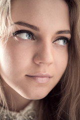 Naklejka premium Blonde attractive girl with large blue eyes closeup