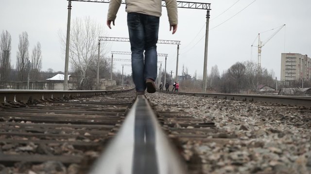 Man walking on railroad tracks
