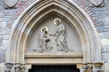 Fototapeta na wymiar Sculpture above entrance of St. Peter Church Na Porici, Prague.