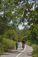 Obraz premium Ciclistas, niño y adultos, en Carril Bici y entre arboles