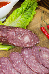 sausages on a wooden plate with vegetables in a restaurant